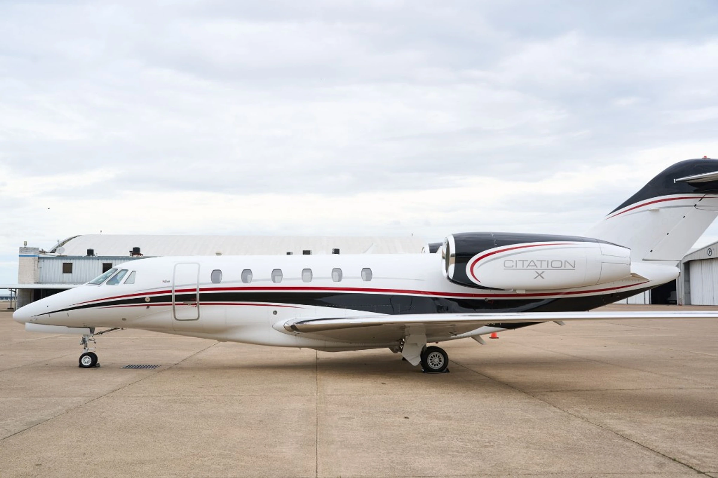 Citation X side profile on the ramp in front of hangars with even light, representing a clearer visible standard