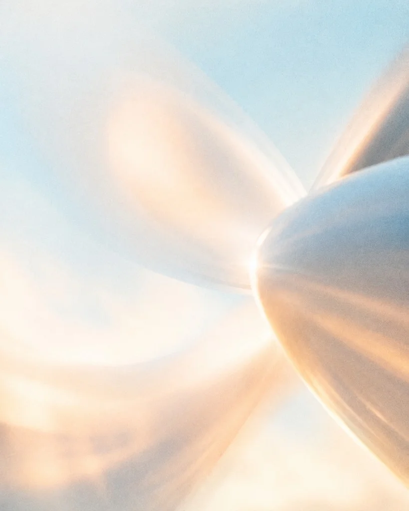 Abstract close-up of a spinning aircraft propeller blurred in motion against a golden sky